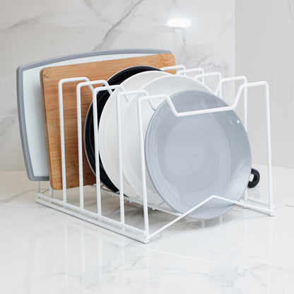 Organizador multifunción en color blanco, con tablas, tapas y utensilios de cocina sobre una encimera
