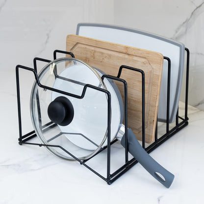 Organizador multifunción en color negro, con tablas, tapas y utensilios de cocina sobre una encimera
