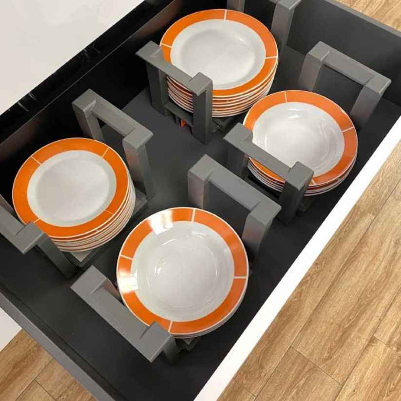 Porta platos Blum varias unidades con platos de borde naranja dentro de un cajón
