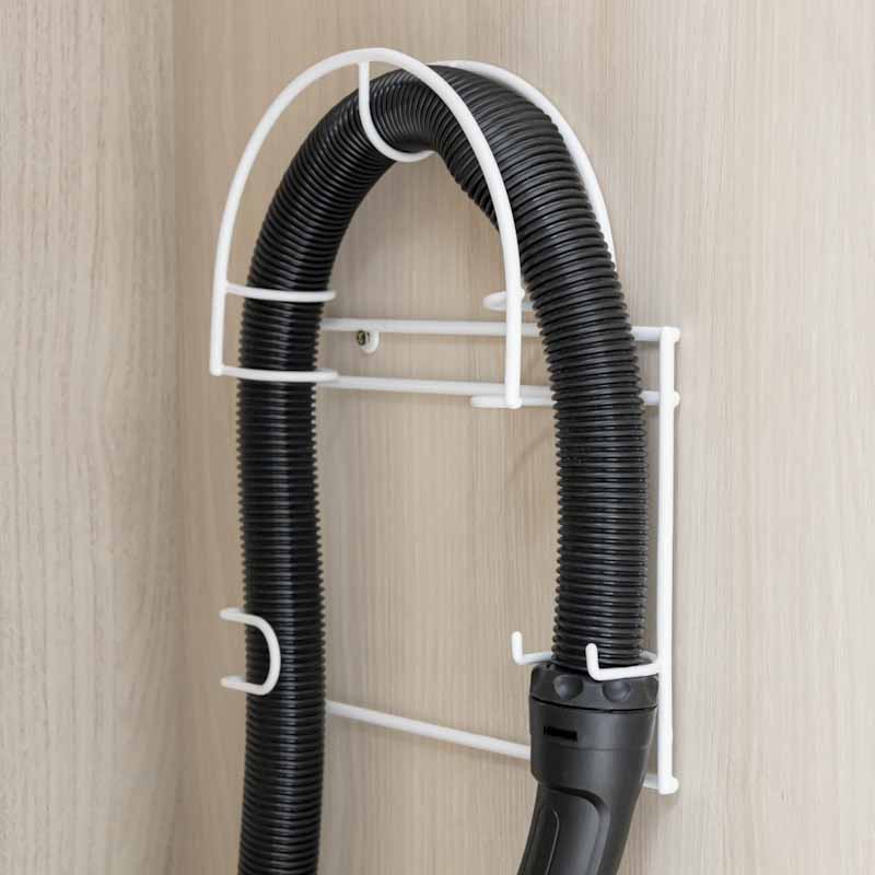 Porta tubo de aspiradora en color blanco, con la manguera de la aspiradora colocada