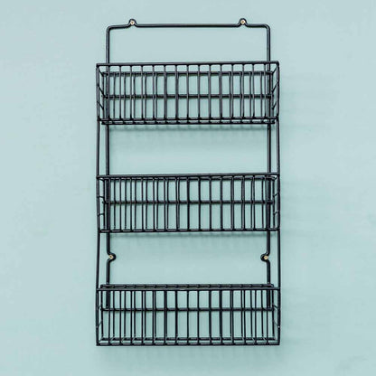Rack auxiliar en color negro, vacío e instalado en la puerta de un mueble